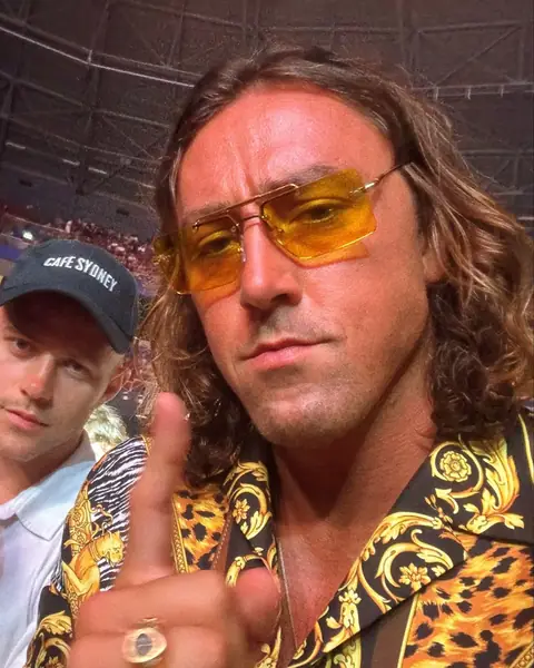 Sol Brah in Ra Optics yellow lenses, pointing at the camera